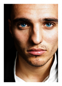 Man with blue eyes and inscrutible expression