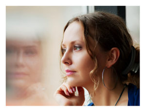 Woman looking through window and contemplating