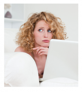 Woman at laptop in bed with worried expression