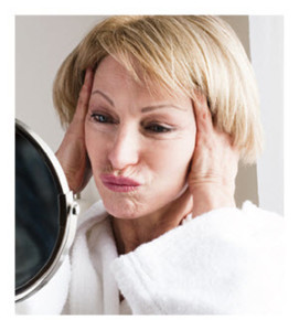 Mature Woman Making a Face Looking in the Mirror