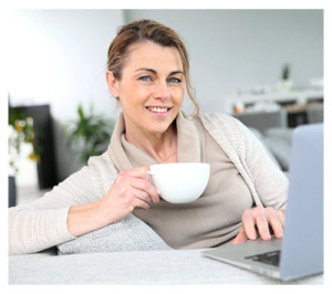 Woman Blogging at Laptop with Coffee