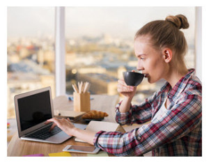 Woman Drinking Coffee and Writing on Laptop